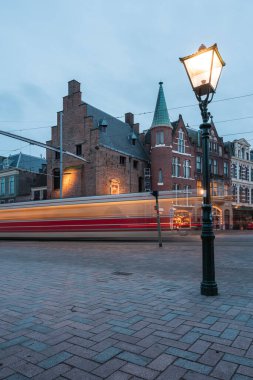 Aralık 2021 Schiedam, Hollanda - Akşamları güzel şehir manzarası klasik binalar ve hareket halindeki bulanık arabalarla 