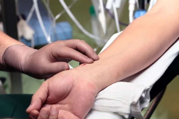 Arzt in Handschuhen misst Puls des Patienten. — Stockfoto