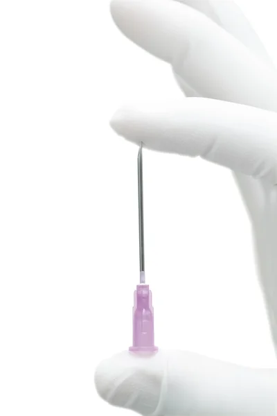 Behandschuhte Hand komprimiert eine scharfe Nadel. — Stockfoto