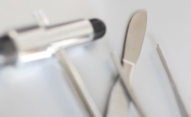 nörolojik çekiçle pince çevrili tıbbi skalpel metal