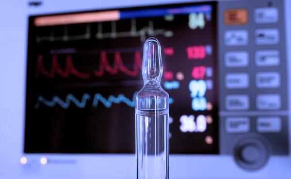 Ampolla transparente contra monitor médico — Foto de Stock