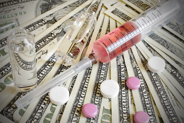 Наркотики, шприцы, флаконы, стоящие на долларовых купюрах
.