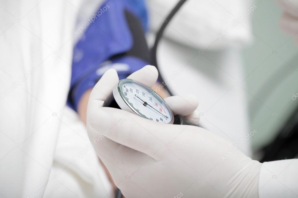 Doctor measuring blood pressure of a patient