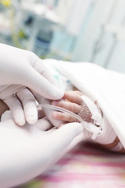 Médico sosteniendo la mano de un niño gravemente enfermo — Foto de Stock