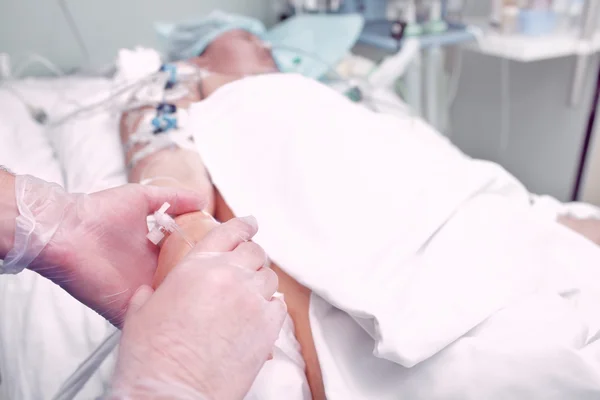 La mano del doctor sostiene tiernamente la mano de un enfermo grave en el hospicio — Foto de Stock