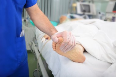 Hastanın muayene. Doktor o bacak dokunur