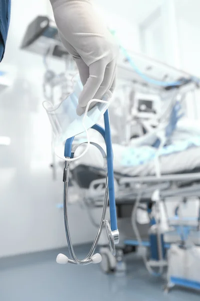 Médecin avec stéthoscope et masque chirurgical dans une salle d'hôpital — Photo