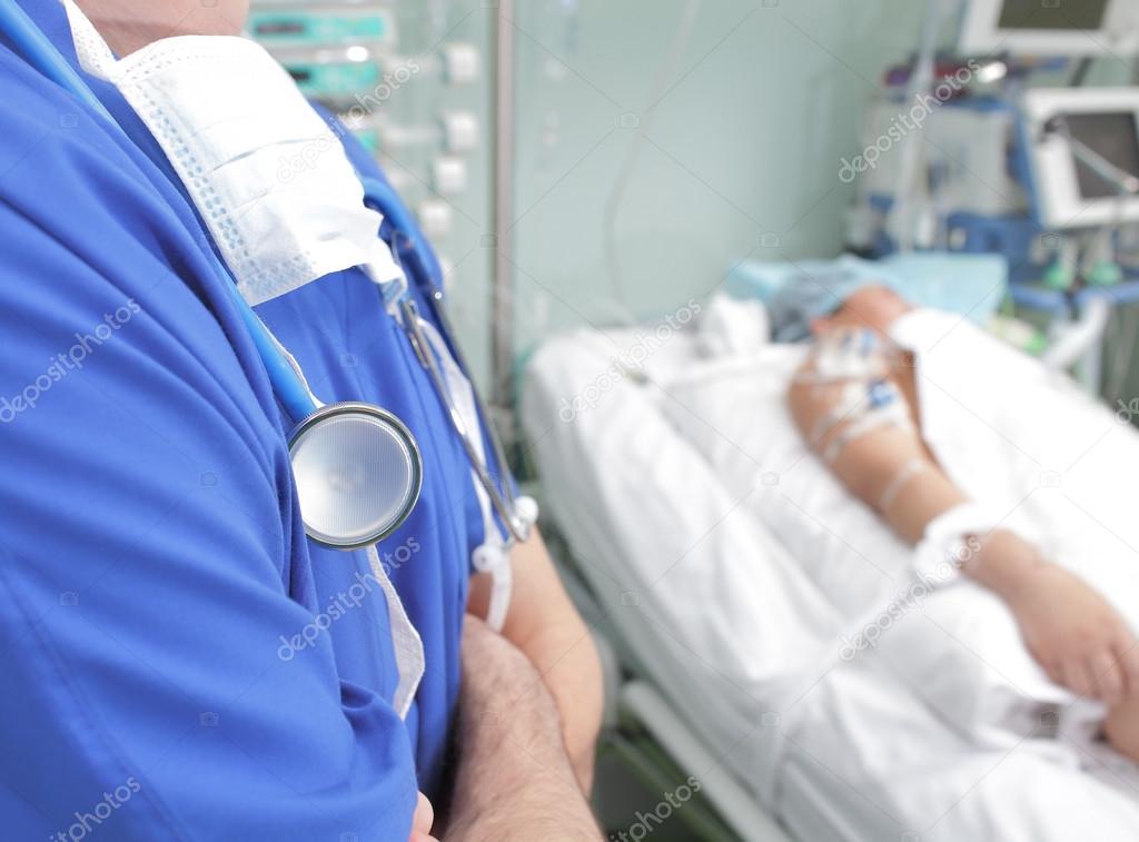 Doctor watching patient in a hospital ward 