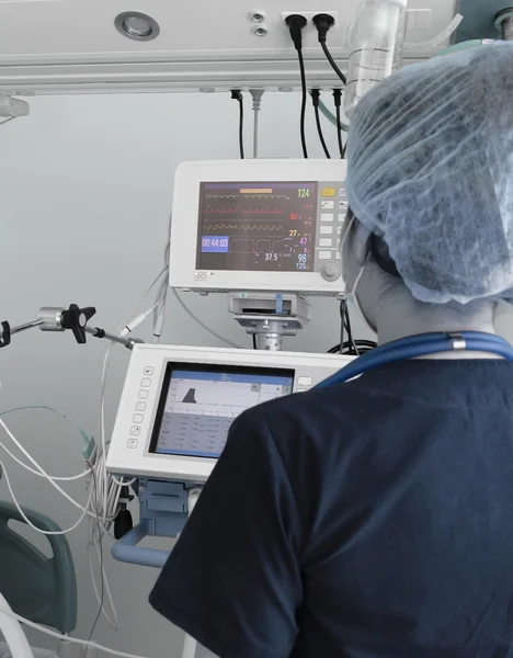 Médica que trabalha com equipamentos eletrônicos na UTI — Fotografia de Stock