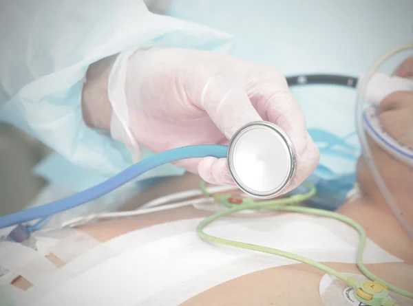 Stéthoscope dans les mains du médecin au backgrou du patient — Photo