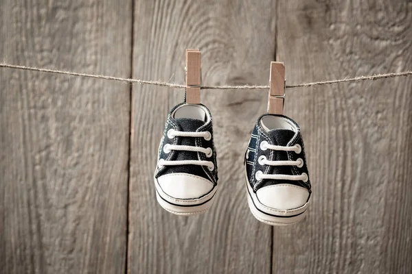 子供の誕生のためのカード 服の上に掛けられる靴 最初の子供の靴 息子の第一歩 誕生の1年 — ストック写真