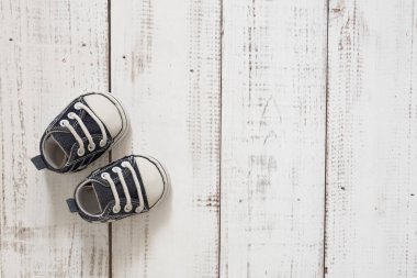 beyaz tahta zeminde bebek ayakkabıları, bebek arka planı, metin için yer, boş alan