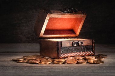 Masasında bozuk paralar olan eski ahşap sandık, göğsü açık, içi aydınlık, peri masalı, gizem, korsan hazinesi, zenginlik, pandora kutusu kavramı