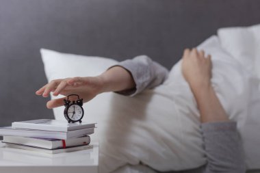 Kadın eli çalar saati sabah 7 'de kapatır, genç kadın sabah erken uyanır, günlük rutin konsept, uyuyakalma