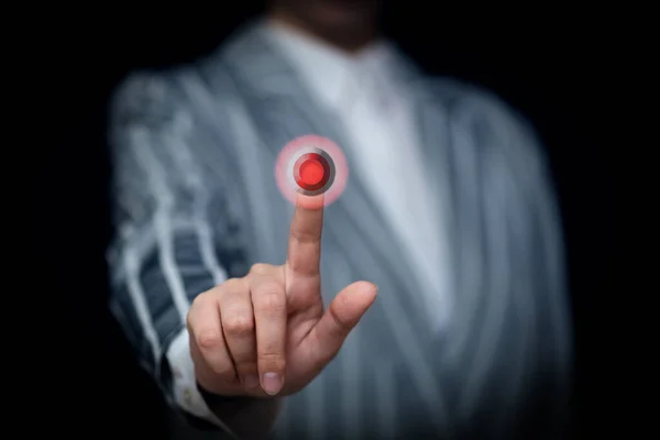 用食指按黑色背景上的红色按钮 — 图库照片