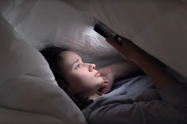 Mujer Joven Utiliza Teléfono Inteligente Cama Por Noche Antes Acostarse Imagen de archivo