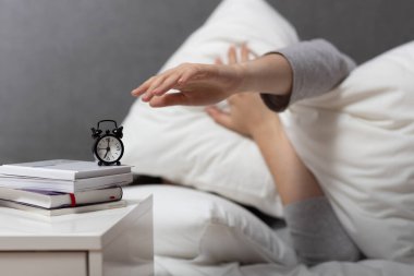 Günlük rutin konsept kadın sabah 7 'de uyanıp alarmı kapatıyor, tembellik.
