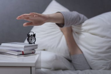Günlük rutin konsept, stresli sabahlar, erken kalkmak zor iş yerinde uyuyakalmak, kadın elinin alarmı kapatması.