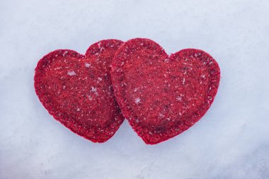 İki kırmızı kalp bir kar arka planında