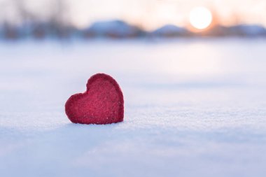 red heart in winter on snow at sunset, i love winter concept,