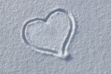 hand drawn heart on white fresh snow, concept of love for winter snow season and valentines day natural outdoors background