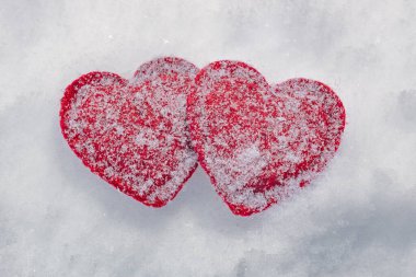 two red hearts in the snow, love concept and valentine's day background