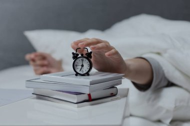 Kadın eli çalar saati sabah erken kapatır, günlük rutin, stres konsepti