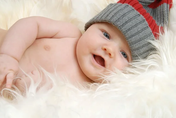 Newborn baby lying on a sheepskin and facing the camera — Stock Photo, Image