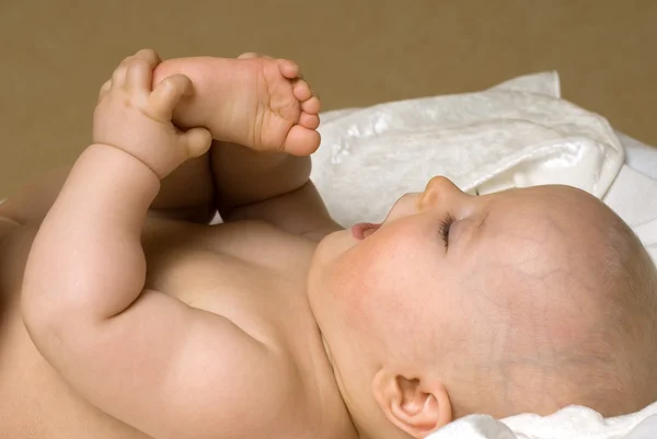 Bebeğin ayakları ile oynuyor