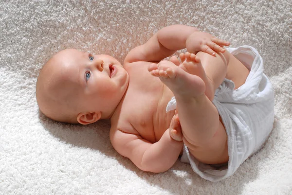 Bebê brinca com seus pés — Fotografia de Stock