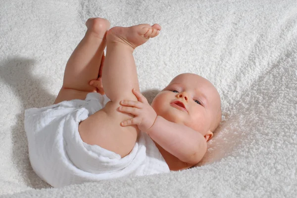 Bambino gioca con i suoi piedi — Foto Stock