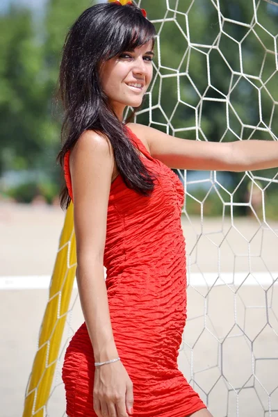 Mulher posando perto da rede de voleibol — Fotografia de Stock