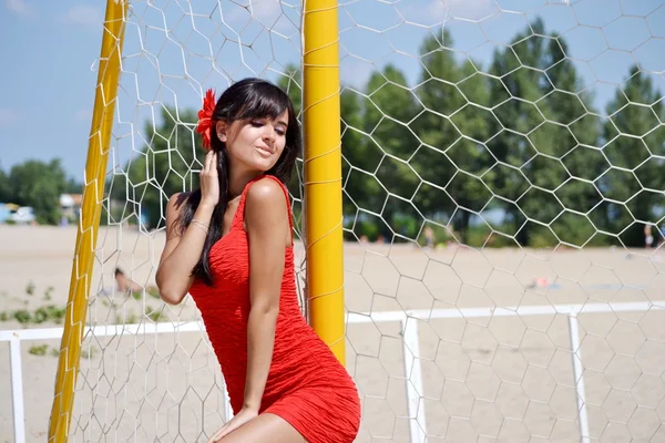 Женщина, позирующая возле волейбольной сетки — стоковое фото