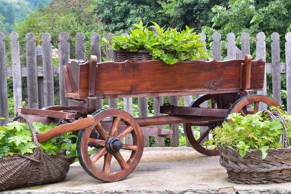 Carrinho de madeira e cestas de vime no quintal Fotos De Bancos De Imagens