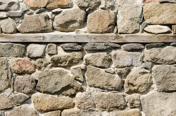 Wall of crushed stone, masonry and wooden plank — Stock Photo, Image