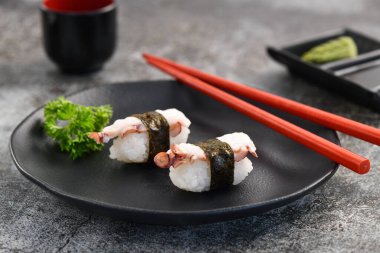 Ahtapot nigiri çifti kara tabakta. Stüdyo çekimi. Ürün resmine kapat.