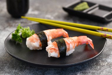 Kara tabakta karides Nigiri çifti. Resmi kapat.