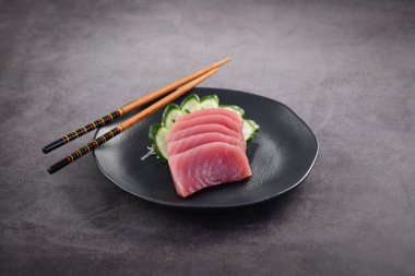 Taze ton balıklı saşimi dilimleri. Stüdyo çekimi arka planda.