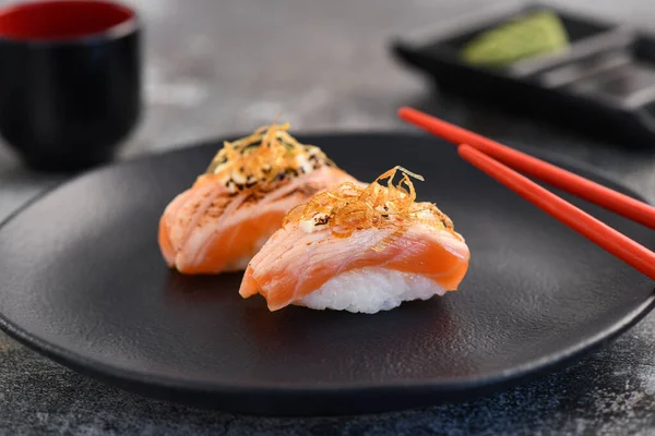 Somon Nigiri çifti siyah tabakta. Resmi kapat.