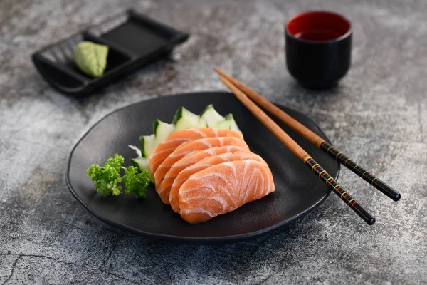 Siyah tabakta taze sashimi dilimleri. Stüdyo çekimi arka planda.