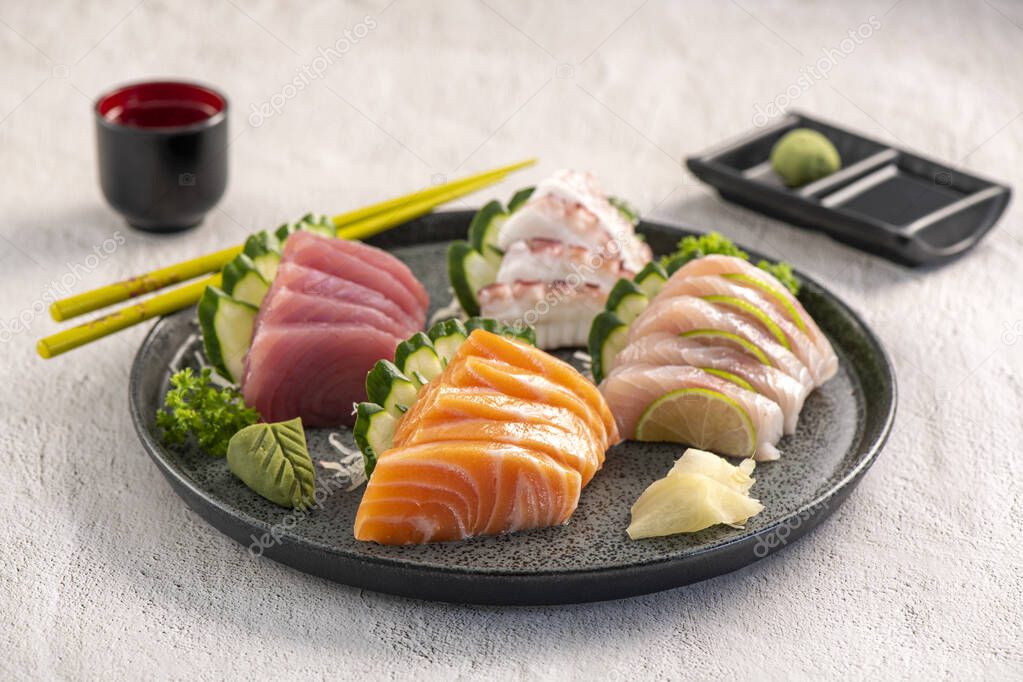 Sashimi mix plate. Studio shoot isolated on slate background. Salmon, tuna, octopus and white fish different kinds of sashimi. Oriental food on Brazilian way!
