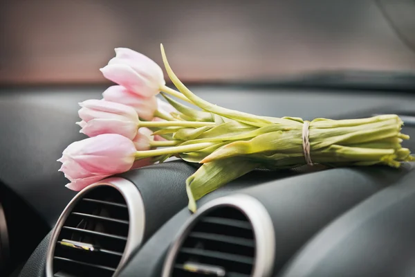 Manojo de tulipanes en el tablero del coche Imágenes De Stock Sin Royalties Gratis
