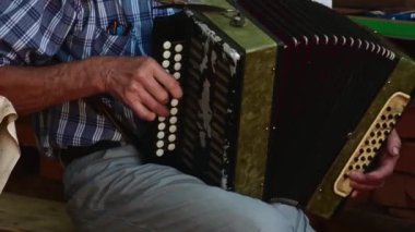 Komuta sizde sandalyede oturan yaşlı bir akordeon açık sahne ile oynarken.