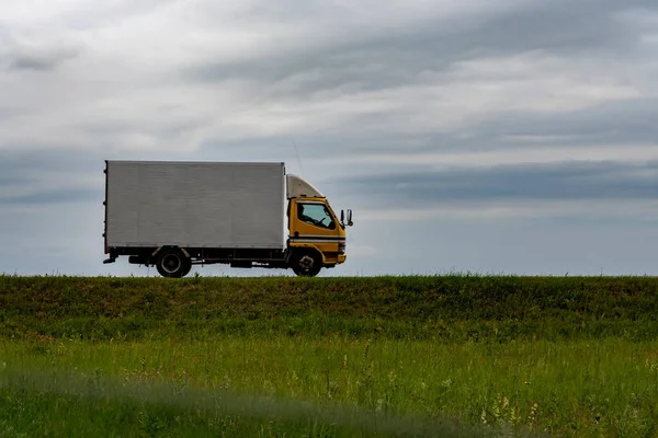 Ciężarówka Jedzie Wzdłuż Drogi Trawa Jest Poniżej Niebo Jest Powyżej — Zdjęcie stockowe