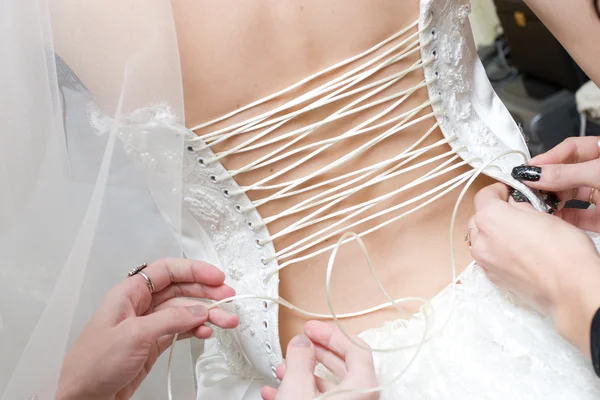 Girls lace up a dress of the bride — Stock Photo, Image