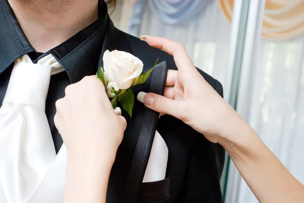 Белая роза в руках девушки у черной свиты мужчины — стоковое фото