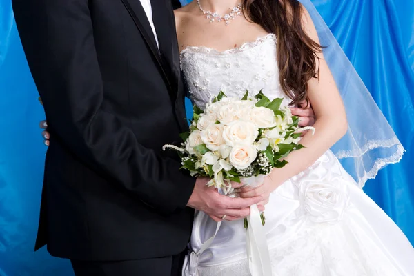 Un beau bouquet de roses entre les mains de la mariée et du marié — Photo