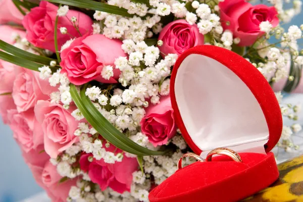 Gold rings and rose bouquet — Stock Photo, Image