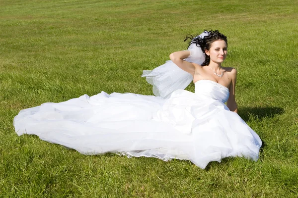 Lachende bruid op het gras — Stockfoto