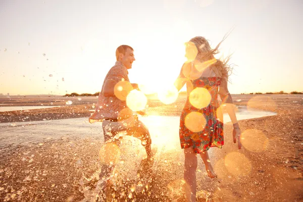 在海滩上奔跑的情侣 免版税图库图片